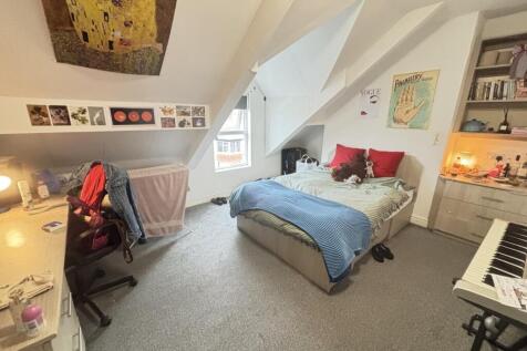 A cozy and well-lit bedroom featuring a large b...