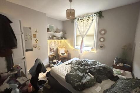 A cozy bedroom featuring a double bed with a wi...