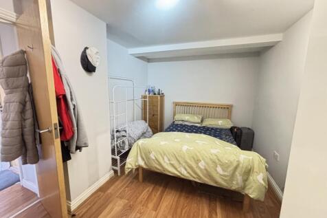 A cozy single bedroom featuring a neatly made b...