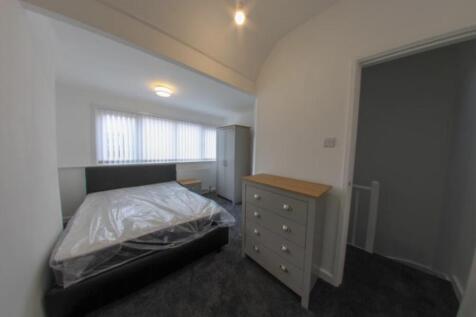 A bright, tidy bedroom featuring a comfortable ...