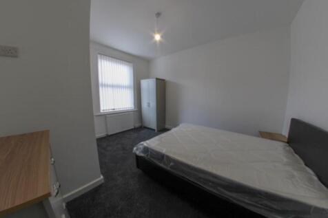 A clean and well-lit single bedroom featuring a...