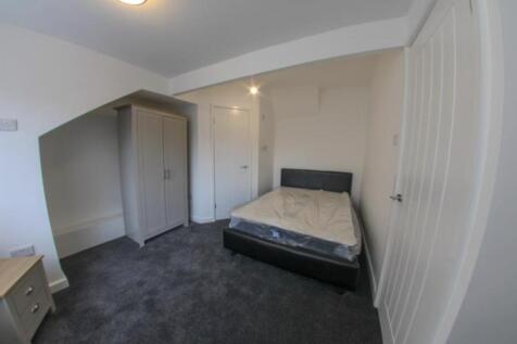 A cozy single bedroom featuring a bed, with nat...