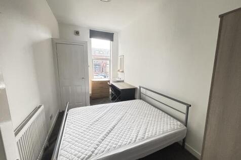 A bright and tidy bedroom featuring a comfortab...