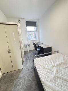 A tidy and bright small bedroom featuring a sin...