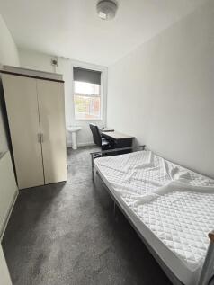 A bright, tidy bedroom featuring a single bed, ...