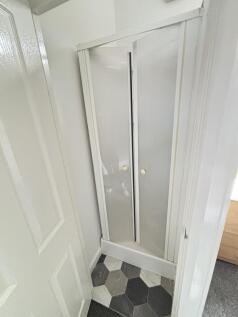 A clean and bright bathroom shower stall with a...