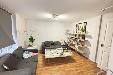 A spacious and well-lit living room featuring m...