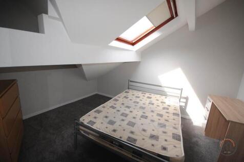 A bright and tidy bedroom with a skylight windo...