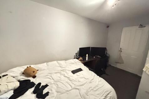 A cozy bedroom featuring a bed with white beddi...