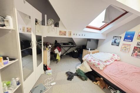 A cozy bedroom under a sloped ceiling featuring...