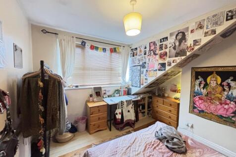 A spacious and well-lit master bedroom featurin...