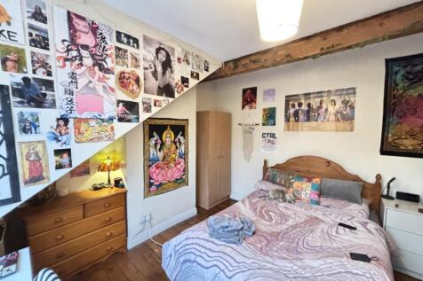 A cozy bedroom featuring a neatly made bed with...