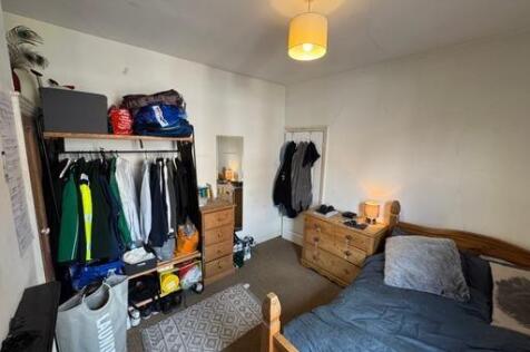 A cozy bedroom featuring a double bed, a wooden...