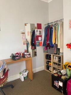 A neatly organized closet with a variety of col...