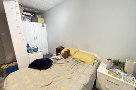 A cozy bedroom featuring a double bed dressed w...