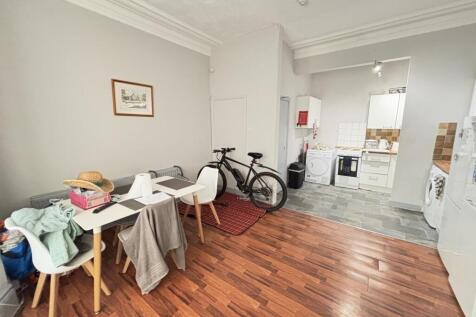 Bright and spacious living room with wooden flo...