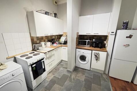 A tidy and well-lit kitchen with modern applian...