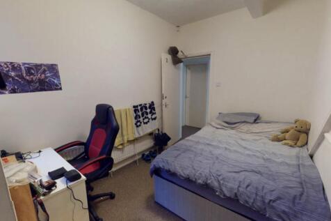 A modest single bedroom featuring a bed with mi...