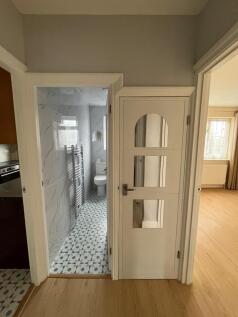 Bright, freshly painted hallway with light wood...