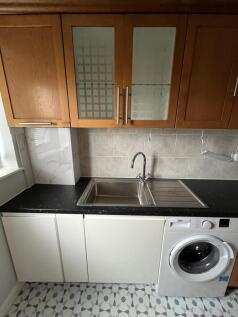 Neat fitted kitchen with oak wall cabinets, bla...