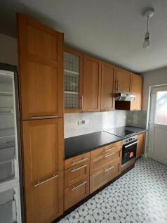 Well-equipped galley kitchen with fitted wooden...