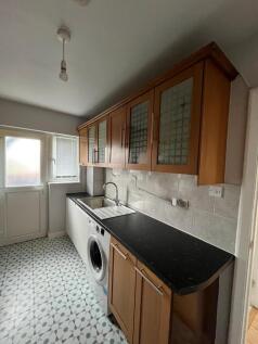 Well-appointed galley kitchen with wooden wall ...
