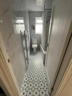 Modern narrow bathroom with patterned tile floo...