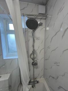 Bright, modern bathroom with a rainfall showerh...