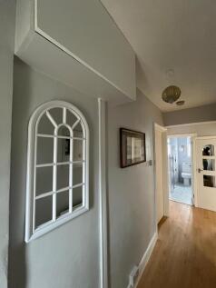 Bright, well-maintained hallway with wooden flo...