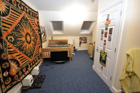 A cozy double bedroom with a wooden bed, colorf...