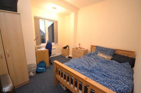 A tidy double bedroom featuring a large bed, de...