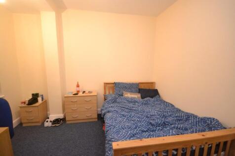 A modest double bedroom with a blue patterned b...