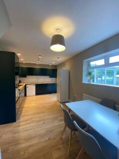 Modern, well-lit kitchen with sleek blue cabine...