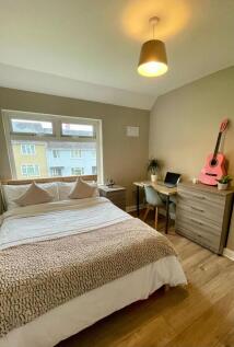 A cozy and well-maintained bedroom with a large...