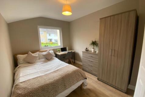 A cozy double bedroom with a desk, clean decor,...