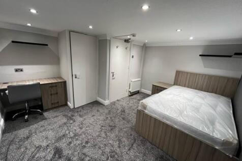 A clean, well-lit bedroom featuring a comfortab...