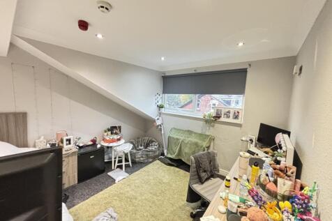 A spacious, well-lit living room with large win...