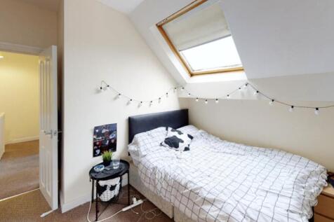 A cozy single bedroom featuring a neatly made b...