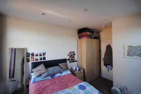 A well-lit bedroom featuring a double bed with ...