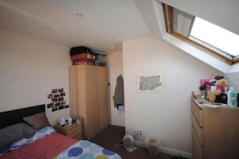 A cozy bedroom with a sloped ceiling featuring ...