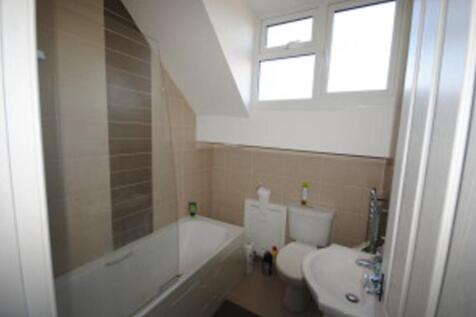 A tidy bathroom with a bathtub, toilet, and sma...