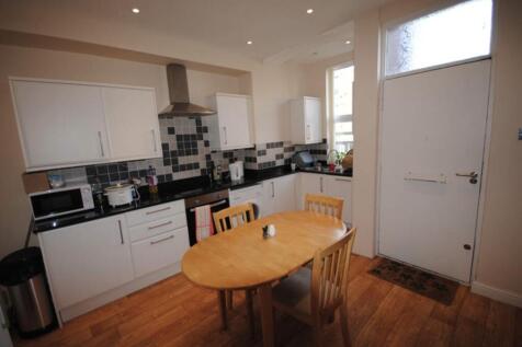 A well-lit kitchen featuring modern white cabin...