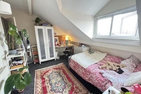 A cozy bedroom with a large window allowing nat...