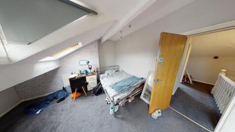 A modest bedroom with a single bed and a small ...