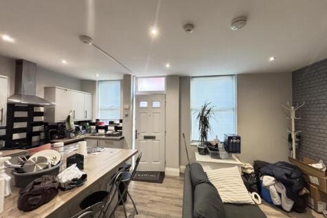 A spacious, modern living room with ample natur...