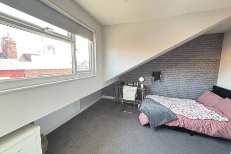 A well-lit bedroom featuring a large window tha...