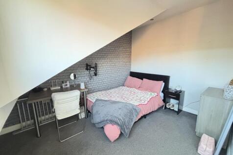 A cozy single bedroom featuring a comfortable b...