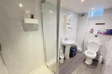 A clean, bright bathroom featuring a toilet, si...