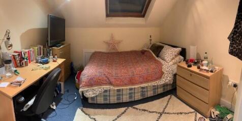 A spacious, well-lit master bedroom featuring a...