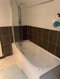 A spacious bathroom featuring a large bathtub w...